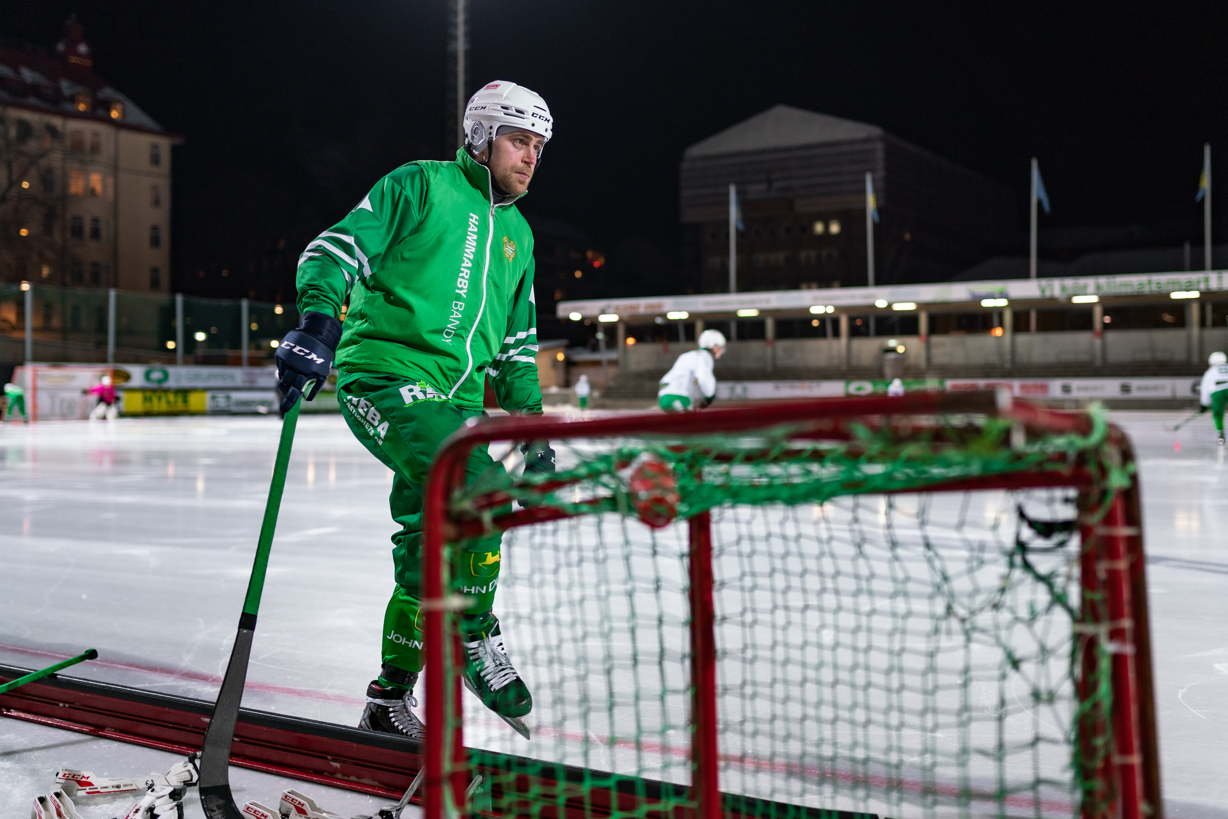 Spelare i grön matchtröja vid målet under kvällsmatch.